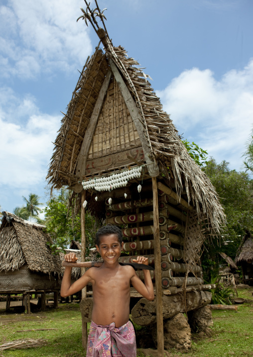 Boy in front of a yam house in a village, Milne Bay Province, Trobriand Island, Papua New Guinea