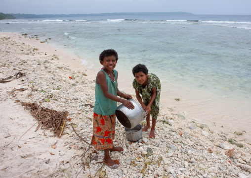 Girls collecting sea water to cook, Milne Bay Province, Trobriand Island, Papua New Guinea
