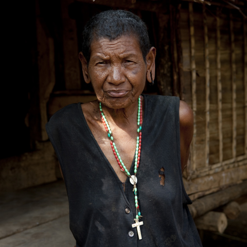 Old woman with a christian cross, Milne Bay Province, Trobriand Island, Papua New Guinea