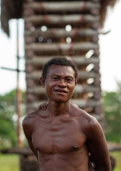 Portrait of a man in front of a yam house, Milne Bay Province, Trobriand Island, Papua New Guinea