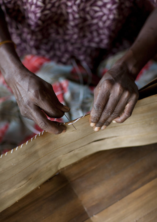 Woman making a traditional skirt with pandanus and banana leaves, Milne Bay Province, Trobriand Island, Papua New Guinea