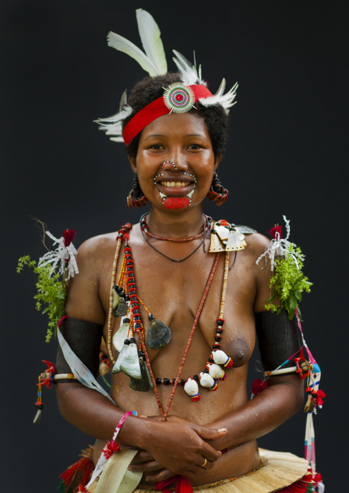 Portrait of a smiling topless tribal woman in traditional clothing, Milne Bay Province, Trobriand Island, Papua New Guinea