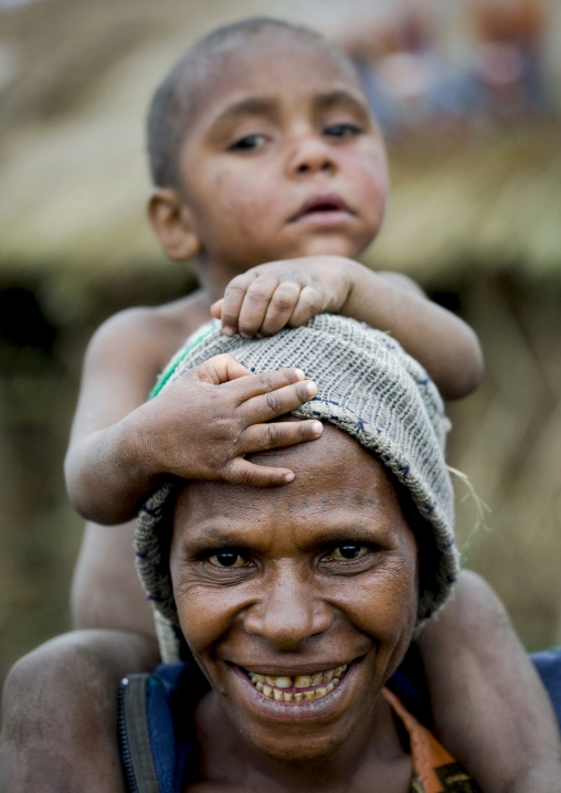 Mother with her child on her shoulders, Western Highlands Province, Mount Hagen, Papua New Guinea