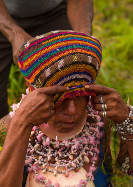 Woman making a headdress during a sing-sing, Western Highlands Province, Mount Hagen, Papua New Guinea