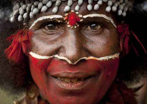 Papuan woman with red tribal makeup on the face, Western Highlands Province, Mount Hagen, Papua New Guinea
