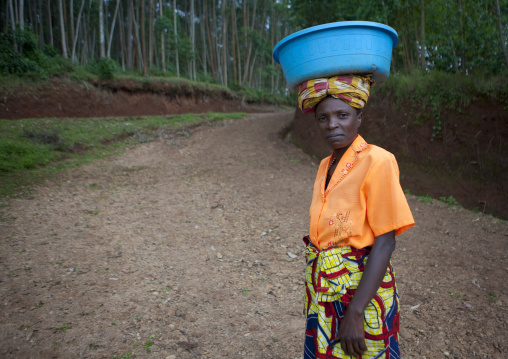 Batwa woman carrying bucket on her head, Western Province, Cyamudongo, Rwanda