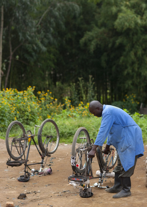 Rwandan man repairing bicycles in the street, Northwest Province, Rehengeri, Rwanda