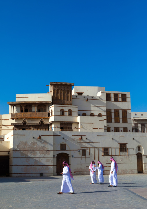 Saudi men in front of renovated historic house with wooden mashrabiyas, Al Madinah Province, Yanbu, Saudi Arabia