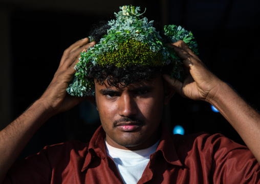 Portrait of a flower man adjusting a floral crown on the head, Jizan province, Sabya, Saudi Arabia