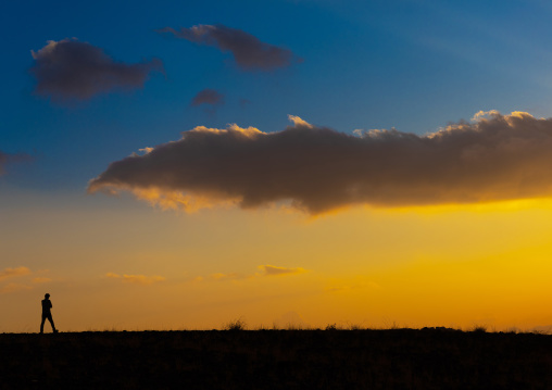 Man silhouette in front of a cloudy sunset, Asir province, Dahran Aljanub, Saudi Arabia