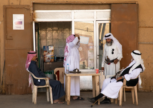 Saudi men drinking coffee in the market, Najran Province, Najran, Saudi Arabia