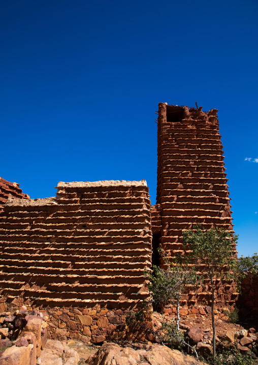 Red stone and mud watchtower with slates in a village, Asir province, Sarat Abidah, Saudi Arabia