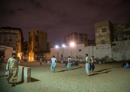 Men playing volley ball in front of old houses with mashrabiyas in al-Balad quarter, Mecca province, Jeddah, Saudi Arabia