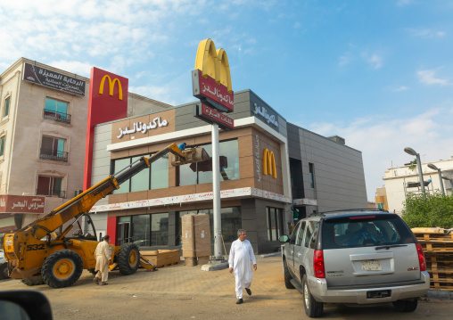 Man washing the windows of a mcdonald restaurant, Mecca province, Jeddah, Saudi Arabia
