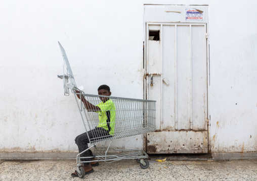 Boy playing with a shopping cart, Jizan Province, Jizan, Saudi Arabia