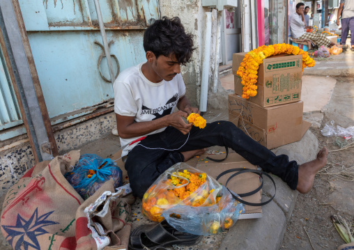 A flower vendor preparing floral garlands and crowns on a market, Jizan Province, Sabya, Saudi Arabia