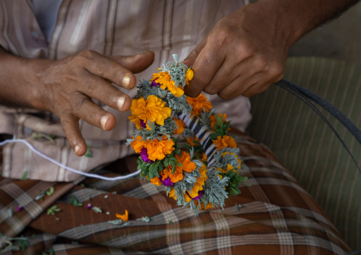 A flower vendor preparing floral garlands and crowns on a market, Jizan Province, Sabya, Saudi Arabia