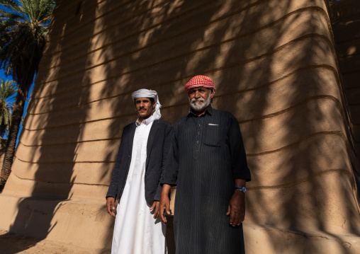 Saudi farmers standing in front of a traditional old mud house, Najran Province, Najran, Saudi Arabia