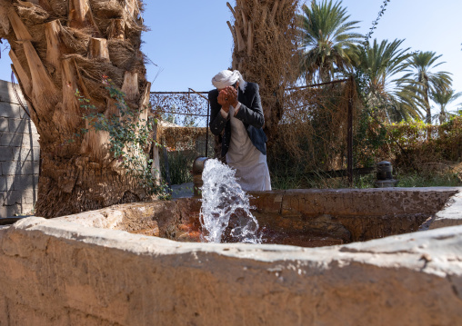 Thirsty saudi man drinking water in a farm well, Najran Province, Najran, Saudi Arabia