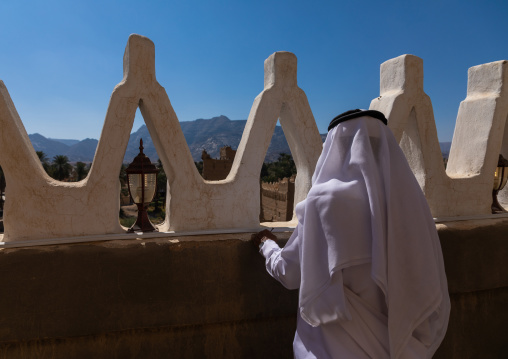Saudi man standing on the terrace of a a traditional old mud house, Najran Province, Najran, Saudi Arabia