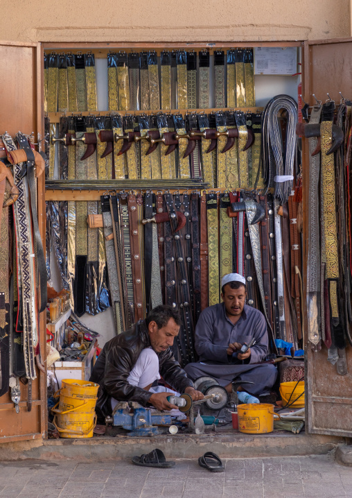 Saudi men prepares a traditional janbiya dagger for sale inside his shop, Najran Province, Najran, Saudi Arabia