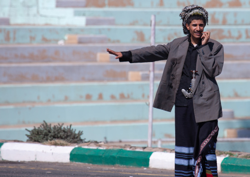 Saudi flower man hitchhiking at roadside
, Asir province, Sarat Abidah, Saudi Arabia