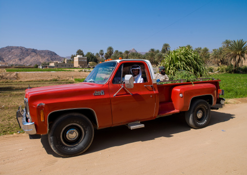 Saudi farmer in a red car near his field, Najran Province, Najran, Saudi Arabia