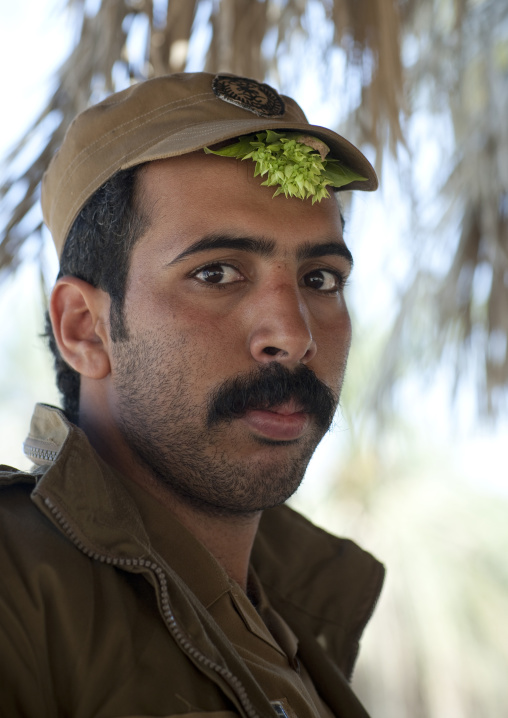 Policeman with basil under his cap to fight headache, Al-Jawf Province, Sakaka, Saudi Arabia