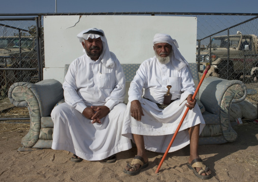 Saudi men sit in a sofa at the camel market, Najran Province, Najran, Saudi Arabia