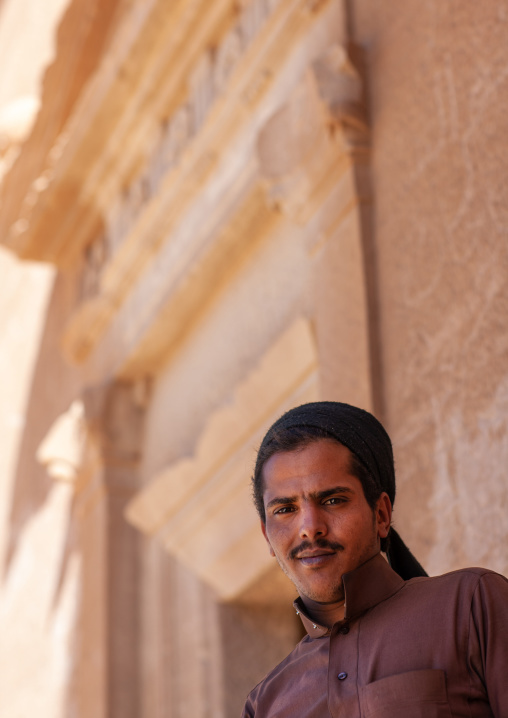 Saudi tourist visiting a nabataean tomb in madain saleh archaeologic site, Al Madinah Province, Al-Ula, Saudi Arabia