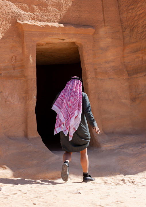 Saudi tourist visiting a nabataean tomb in madain saleh archaeologic site, Al Madinah Province, Al-Ula, Saudi Arabia