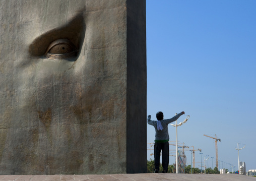 Man making gymnastic in front of Cesar modern art on the corniche, Mecca province, Jeddah, Saudi Arabia