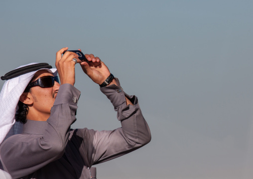 Saudi tourist taking pictures with his mobile phone, Riyadh Province, Riyadh, Saudi Arabia