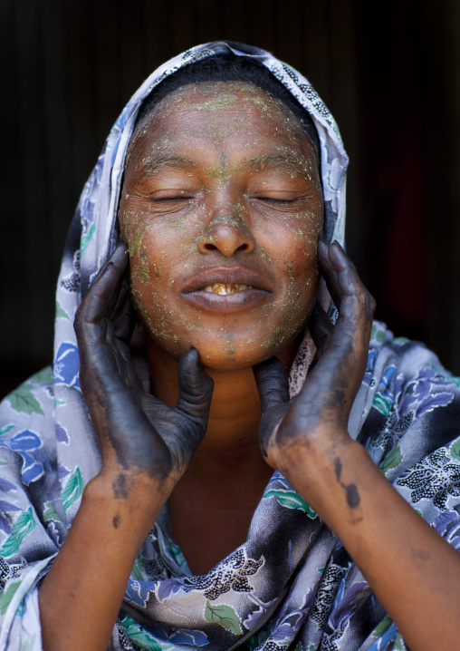 A Woman Wearing Hennah Tattoos On Her Hands Is Putting Qasil On Her Face, Hargeisa, Somaliland