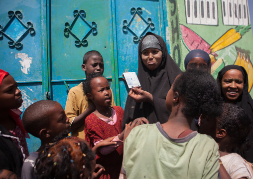 Somali girl discovering her picture on a polaroid, Woqooyi Galbeed region, Hargeisa, Somaliland