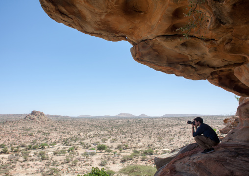 Western tourist taking pictures in laas geel rock art caves, Woqooyi Galbeed region, Hargeisa, Somaliland