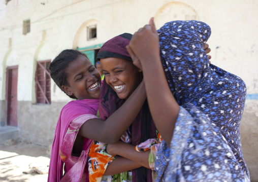 Three Girls Wearing Colorful Hijabs Playing In A Street, Berbera, Somaliland