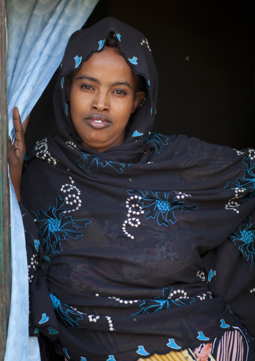 Portrait Of A Young Woman Wearing A Purple Shawl Opening Blue Curtains, Somaliland
