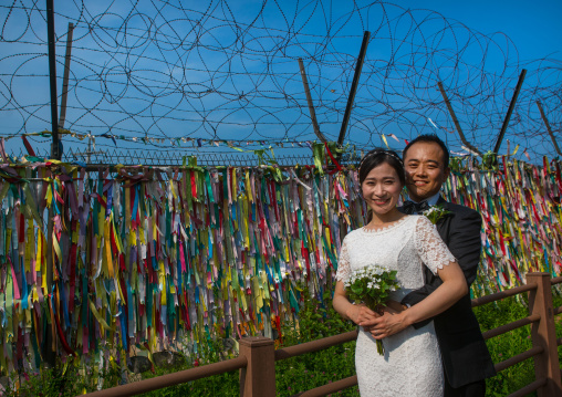 North korean defector joseph park with his south korean fiancee juyeon in front of messages of peace written on ribbons left on dmz, Sudogwon, Paju, South korea