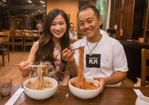 North korean defector joseph park with his south korean fiancee called juyeon eating cold noodles, National capital area, Seoul, South korea