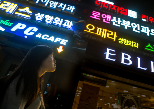 North korean teen defector in front of neon lights in the street, National capital area, Seoul, South korea
