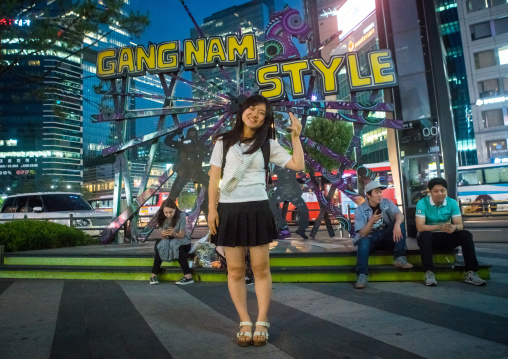 North korean teen defector in front of a gangnam style logo, National capital area, Seoul, South korea