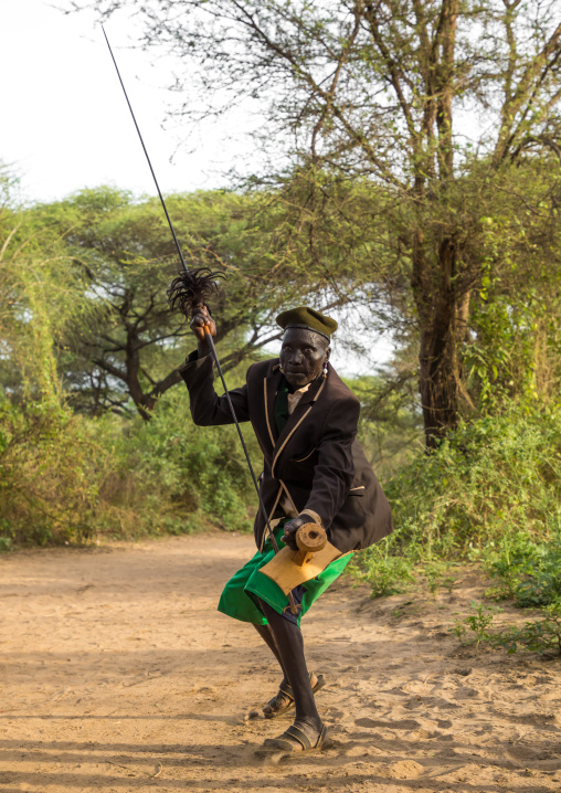 Toposa tribe man dancing with a spear and a wooden seat, Namorunyang State, Kapoeta, South Sudan