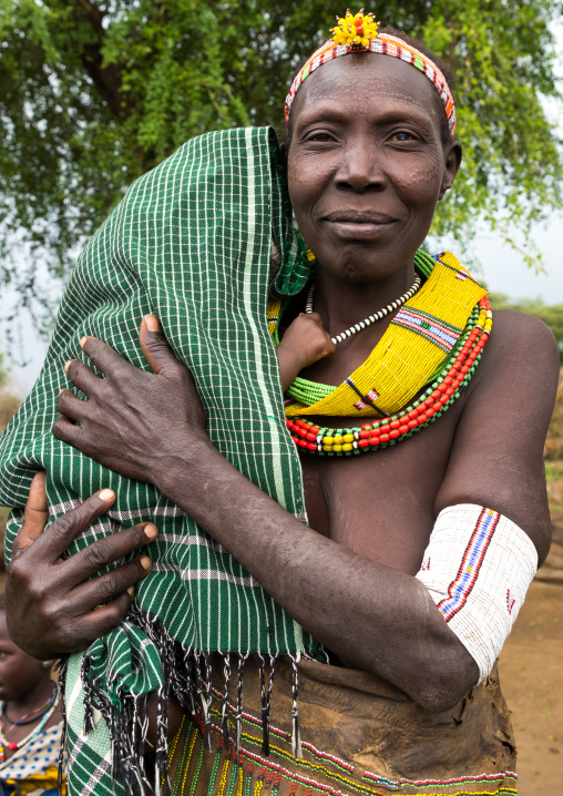 Toposa tribe woman with her baby hidden under a shawl, Namorunyang State, Kapoeta, South Sudan