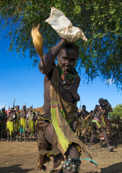 Toposa tribe woman in traditional clothing dancing during a ceremony, Namorunyang State, Kapoeta, South Sudan