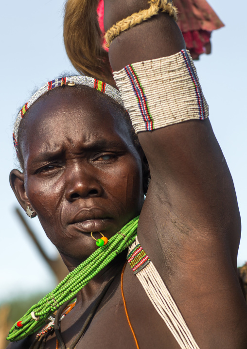 Toposa tribe woman in traditional clothing dancing during a ceremony, Namorunyang State, Kapoeta, South Sudan