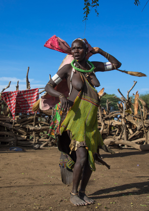 Toposa tribe woman in traditional clothing dancing during a ceremony, Namorunyang State, Kapoeta, South Sudan