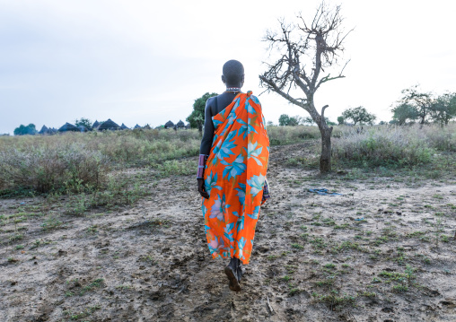 Toposa tribe woman walking on a muddy path, Namorunyang State, Kapoeta, South Sudan