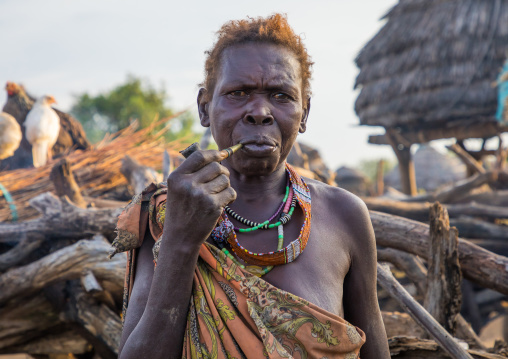 Senior Toposa tribe woman smoking pipe in a village, Namorunyang State, Kapoeta, South Sudan