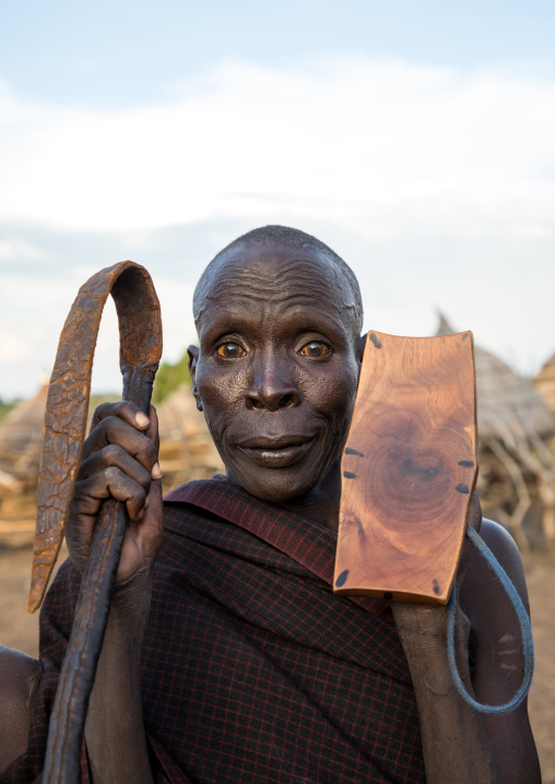 Portrait of a Toposa tribe man holding a whip and a wooden seat, Namorunyang State, Kapoeta, South Sudan